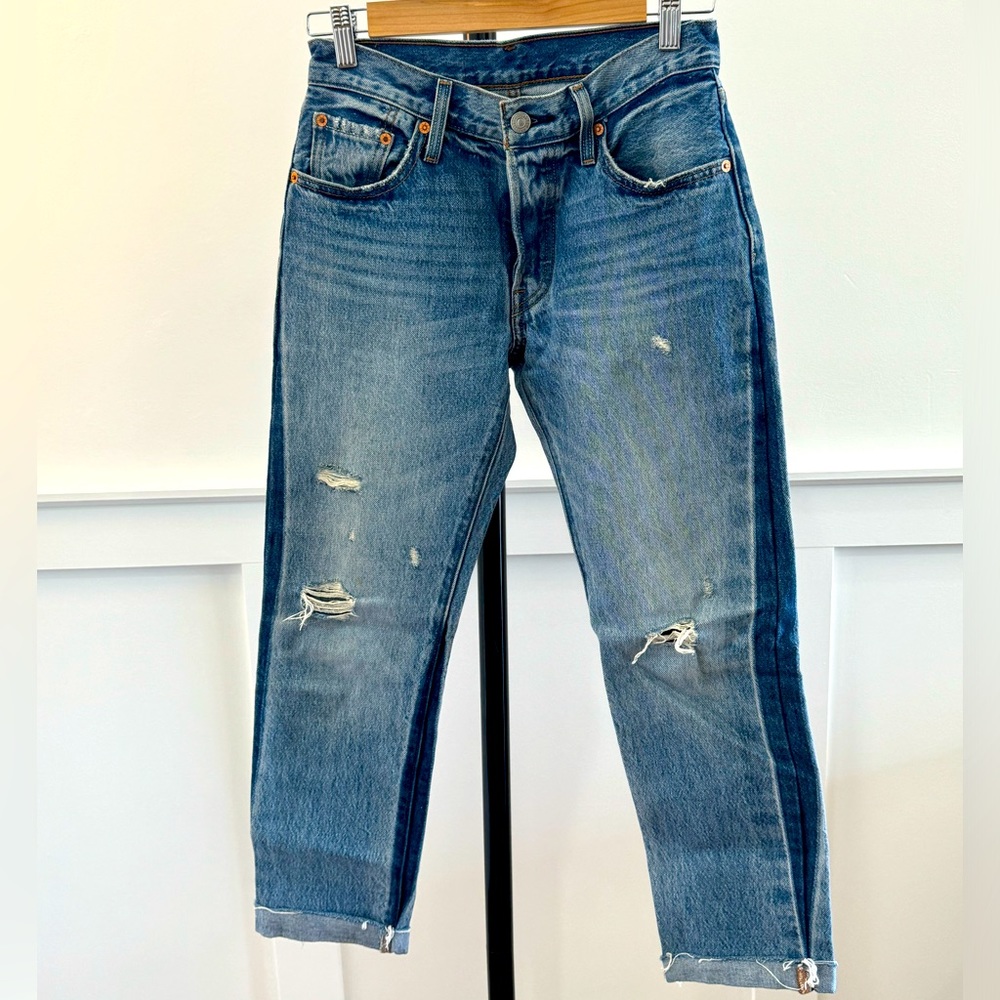 Levi’s 501 jeans with darker denim seam and ripped details, size 25